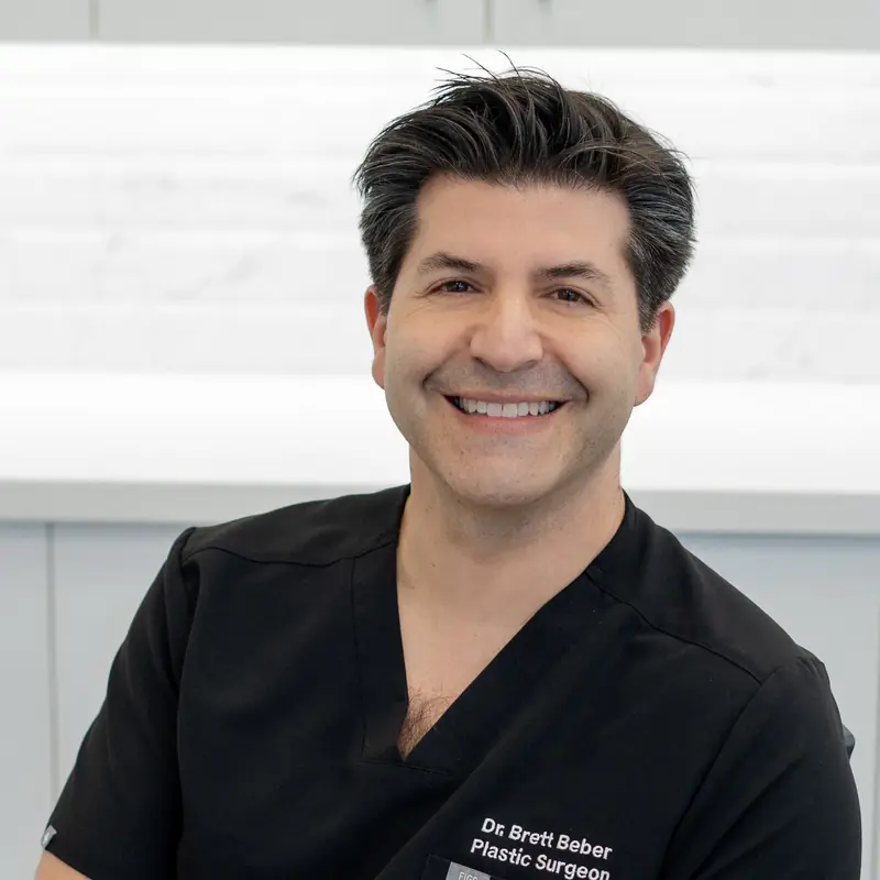 Dr. Brett Beber smiling in surgical scrubs